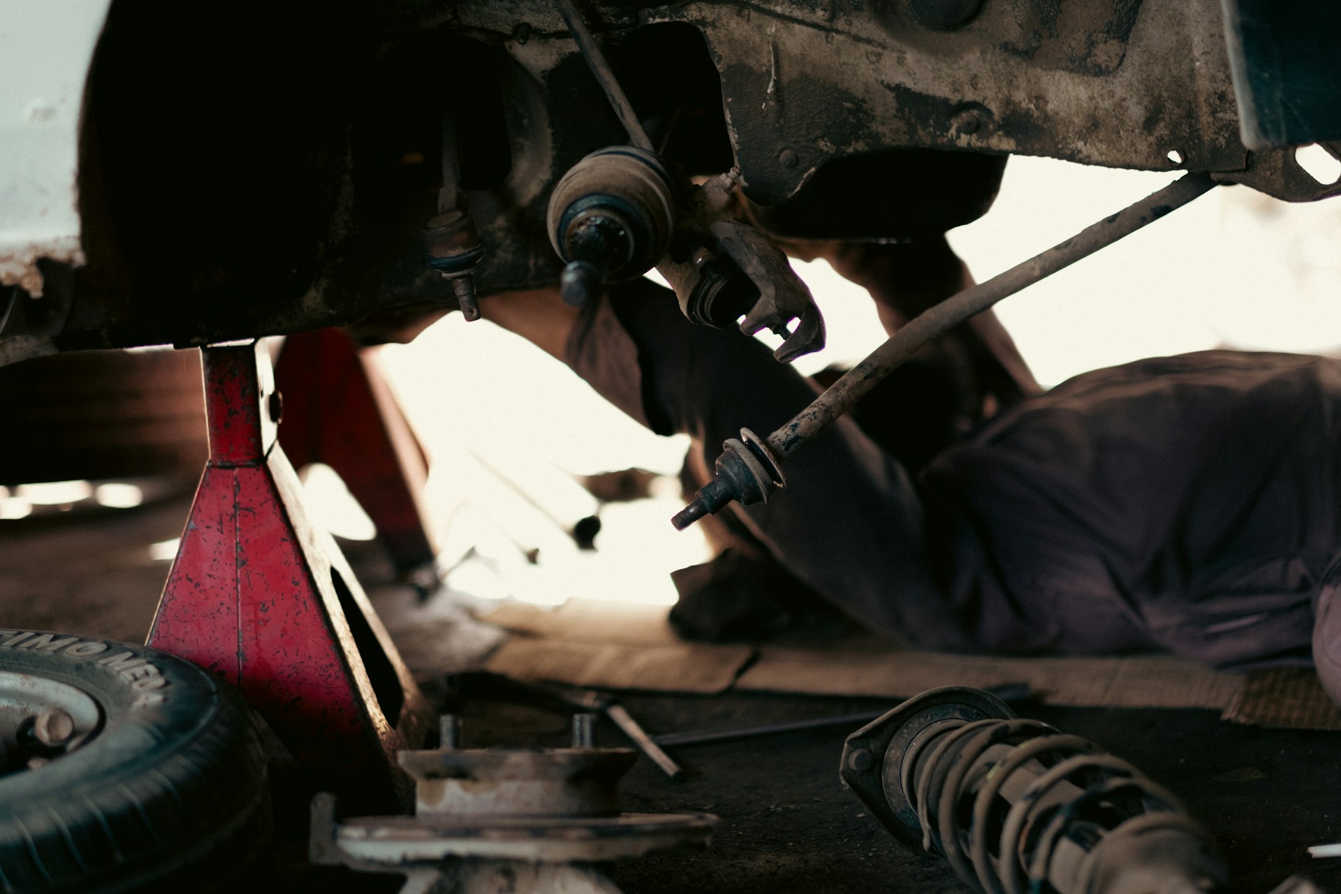 Technician inspecting the drivetrain under a vehicle
